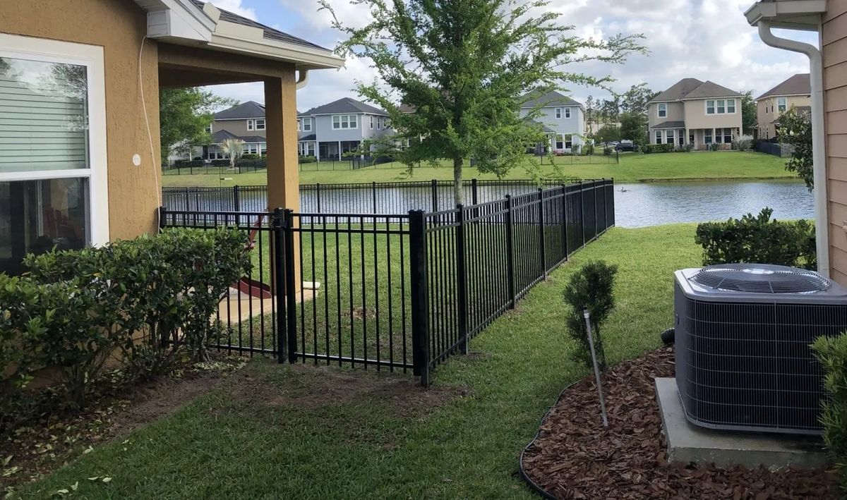 Black aluminum ornamental fence beside a pond